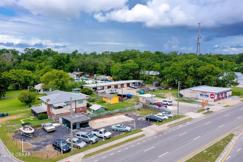An aerial view shows a commercial property with a parking lot and several buildings — 1520 N NOVA & 10TH ROAD, DAYTONA BEACH, FL