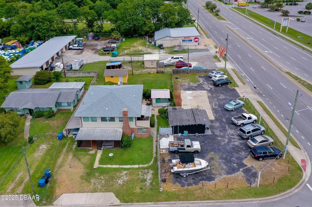 An aerial view shows a house with a large parking lot and several vehicles — 1520 N NOVA & 10TH ROAD, DAYTONA BEACH, FL