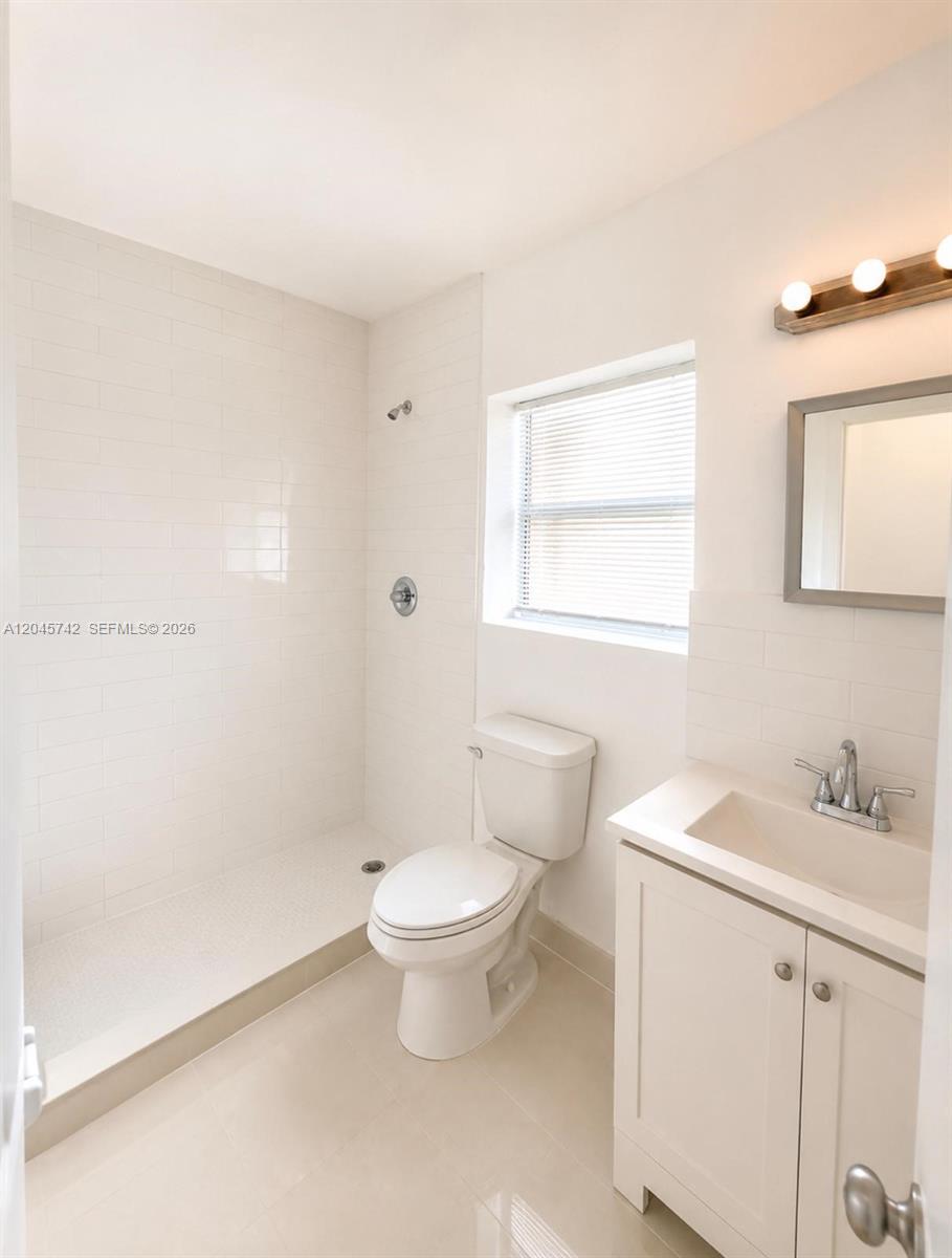 A bathroom features a walk-in shower, a white toilet, and a vanity with a sink — 7600 Dickens Ave # 2, Miami Beach FL 33141, MIAMI BEACH, FL