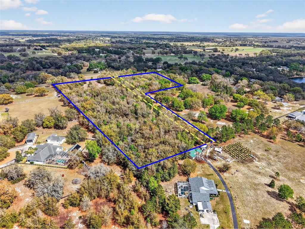 An aerial view shows a wooded plot of land outlined in blue and yellow — 3800 DOUBLE D CIRCLE R, LADY LAKE, FL