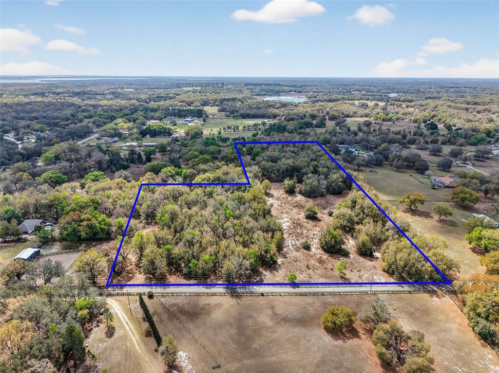 An aerial view shows a large, partially wooded plot of land outlined in blue — 3800 DOUBLE D CIRCLE R, LADY LAKE, FL