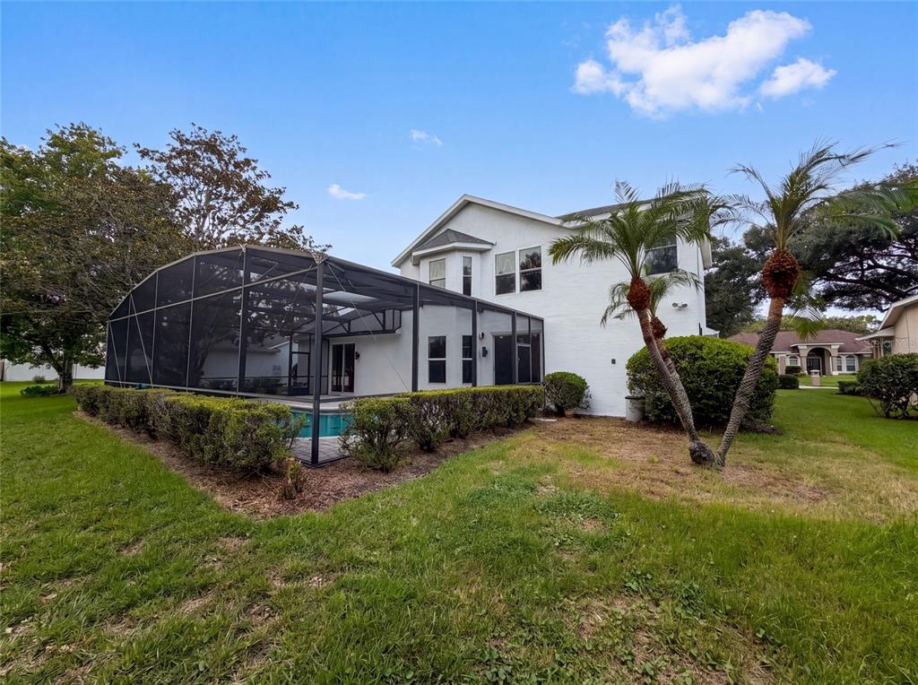 A two-story white house features a screened-in pool enclosure and two palm trees — 1379 HAMPSTEAD TERRACE, OVIEDO, FL