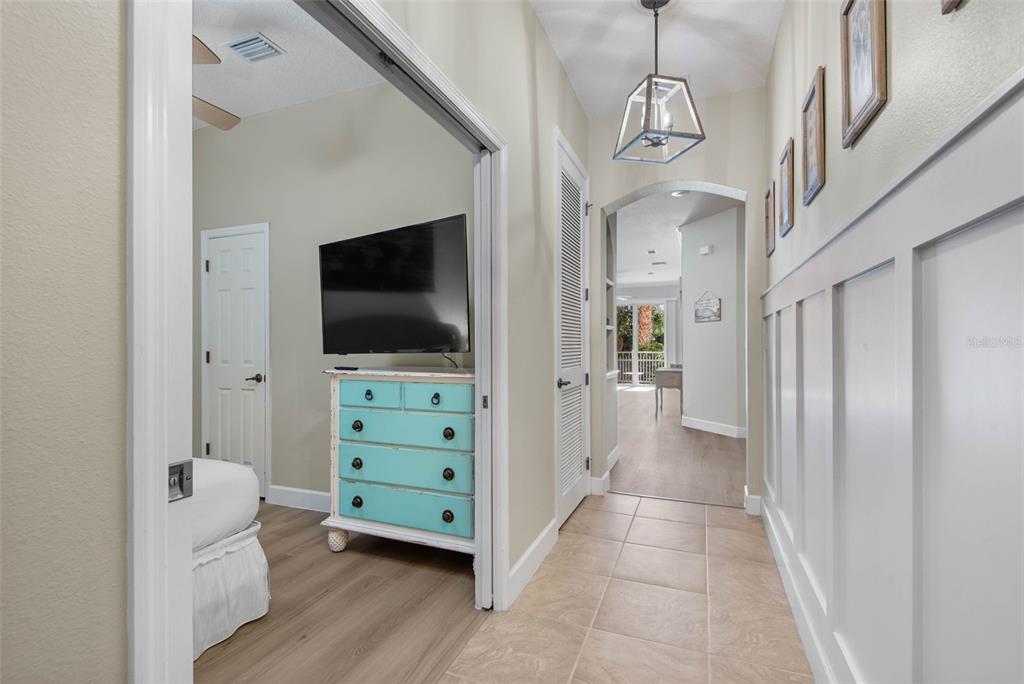 A hallway with tiled floors leads to a bedroom featuring a light blue dresser — 15 OCEAN CREST WAY UNIT 1314, PALM COAST, FL