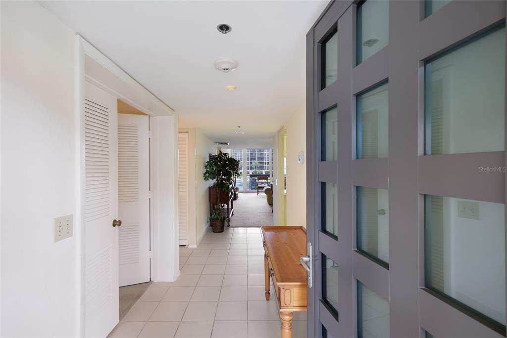 A view from an entryway into a hallway with tiled floors and a wooden console — 1095 GULF OF MEXICO DRIVE UNIT 102, LONGBOAT KEY, FL