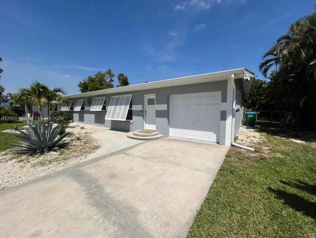 A single-story gray house features a white garage door, white shutters, and a concrete driveway — 5221 York Ct # 0, Cape Coral FL 33904, CAPE CORAL, FL