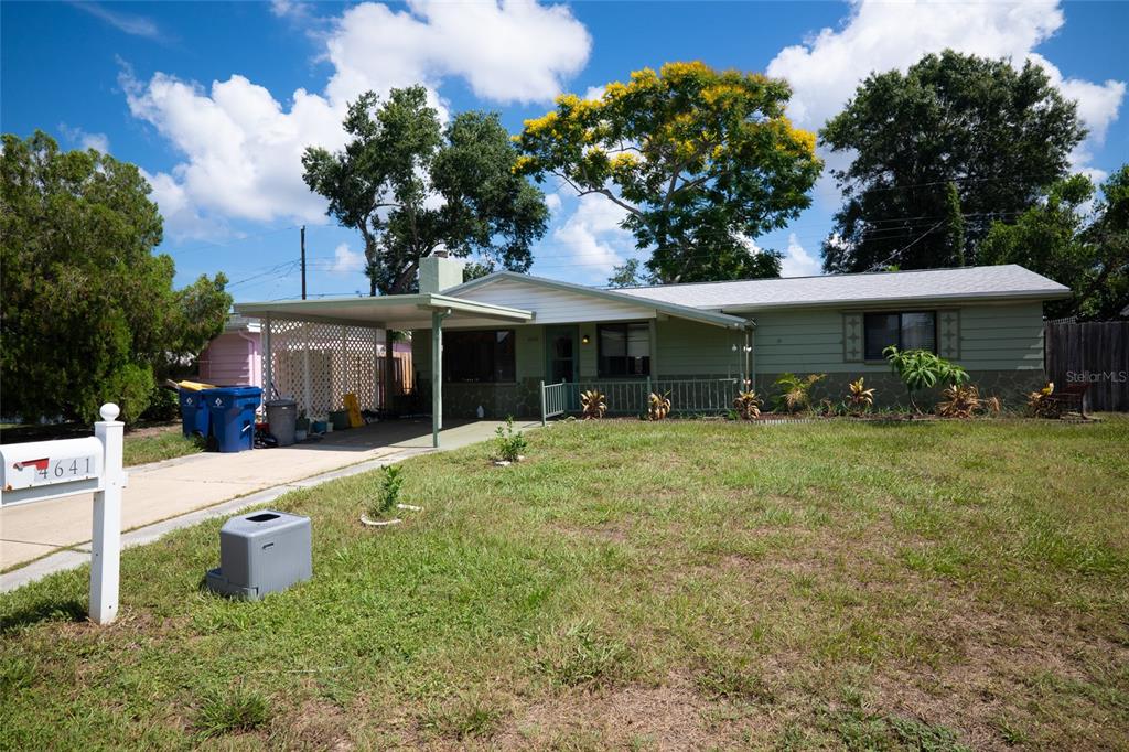 A single-story house with a carport, light green siding, and a grassy front yard — 4641 AEGEAN AVENUE, HOLIDAY, FL