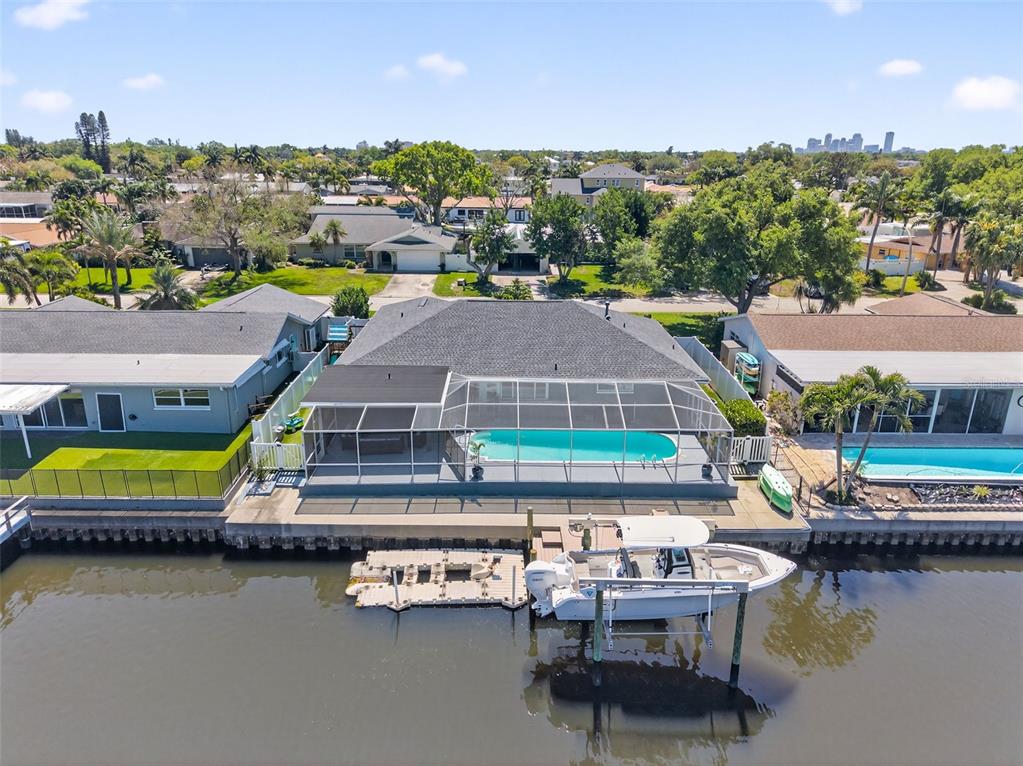 An aerial view of a waterfront house with a pool, screened lanai, and boat lift — 1435 48TH AVENUE NE, ST PETERSBURG, FL