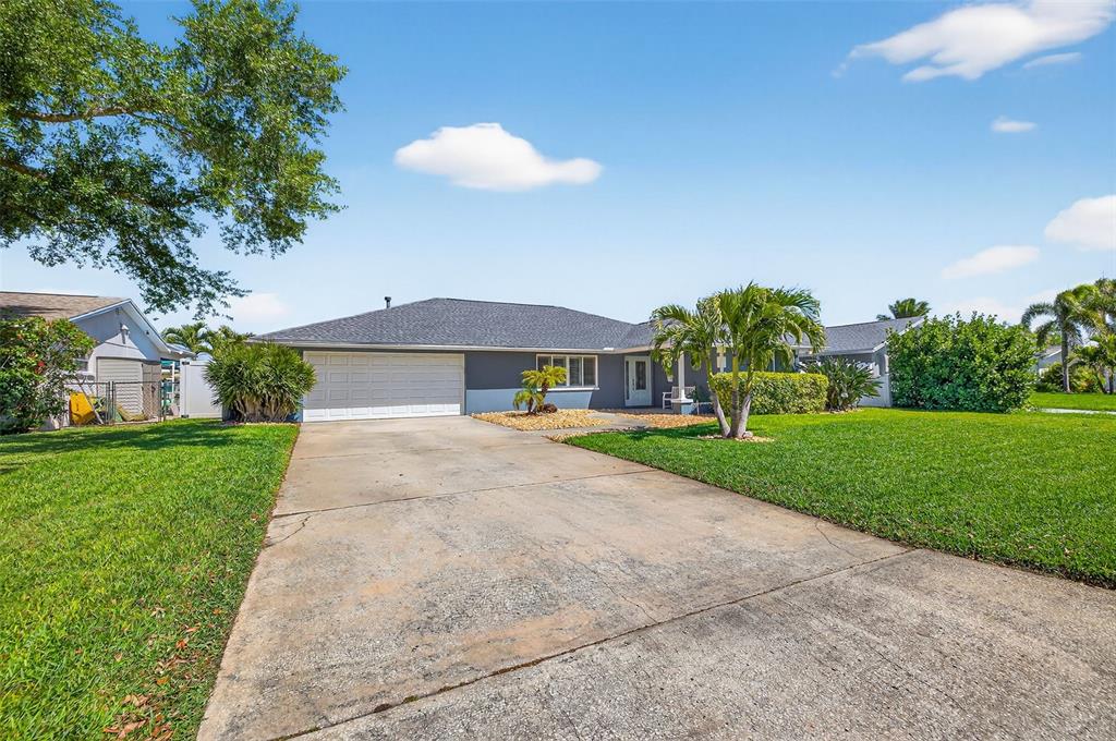 A single-story house with a gray exterior, a two-car garage, and a concrete driveway — 1435 48TH AVENUE NE, ST PETERSBURG, FL