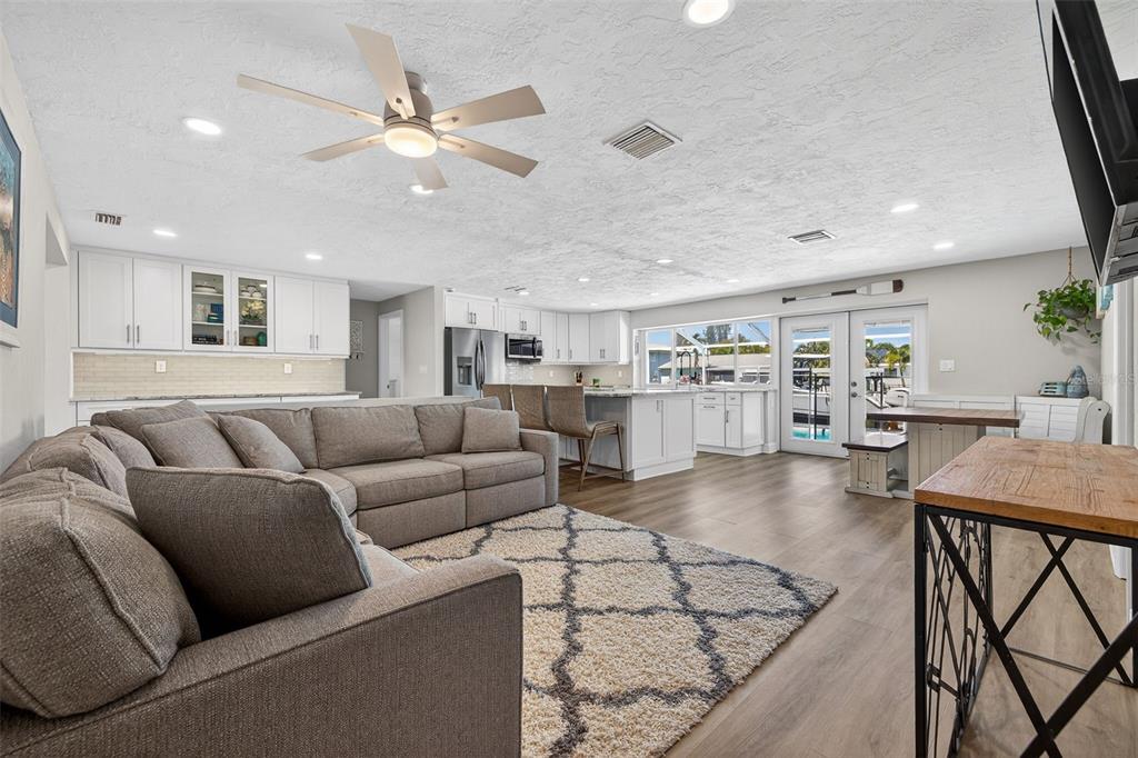 A spacious open-concept living room and kitchen featuring a large sectional sofa and island — 1435 48TH AVENUE NE, ST PETERSBURG, FL