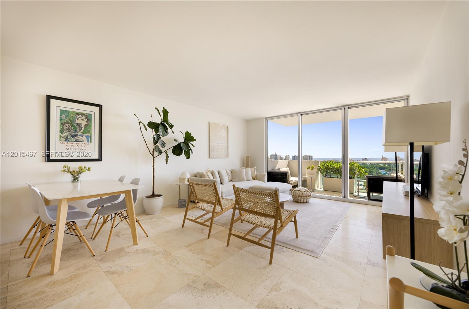 A bright living and dining area features tile floors, modern furniture, and a balcony view — 1200 West Ave # 1410, Miami Beach FL 33139, MIAMI BEACH, FL
