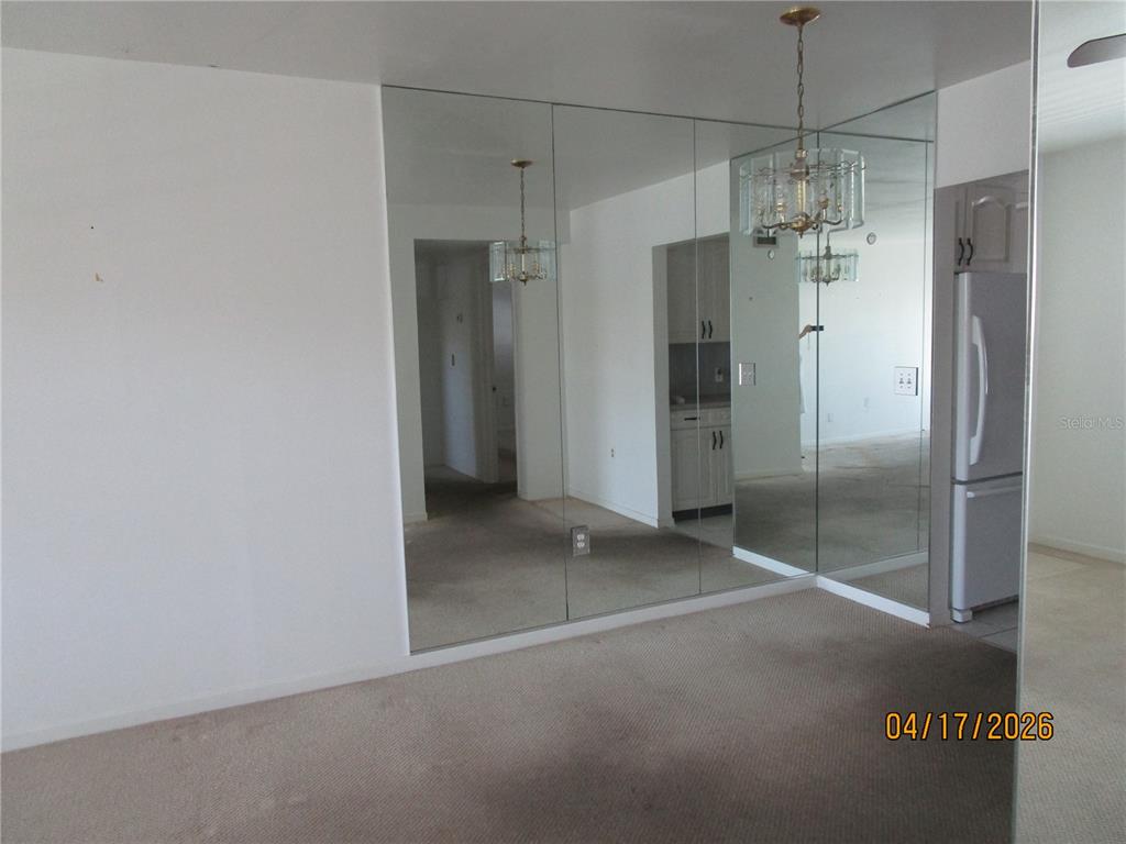 A carpeted room features a large wall of floor-to-ceiling mirrors and a hanging chandelier — 5900 21ST STREET N UNIT 15, ST PETERSBURG, FL