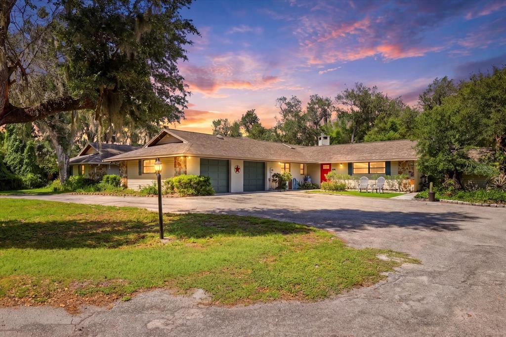 A single-story house with a two-car garage and a red front door at sunset — 5850 VANDERIPE ROAD, SARASOTA, FL