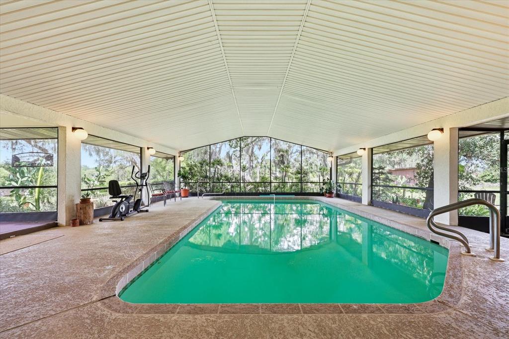 An indoor swimming pool is enclosed by a screened-in lanai with a vaulted ceiling — 5850 VANDERIPE ROAD, SARASOTA, FL