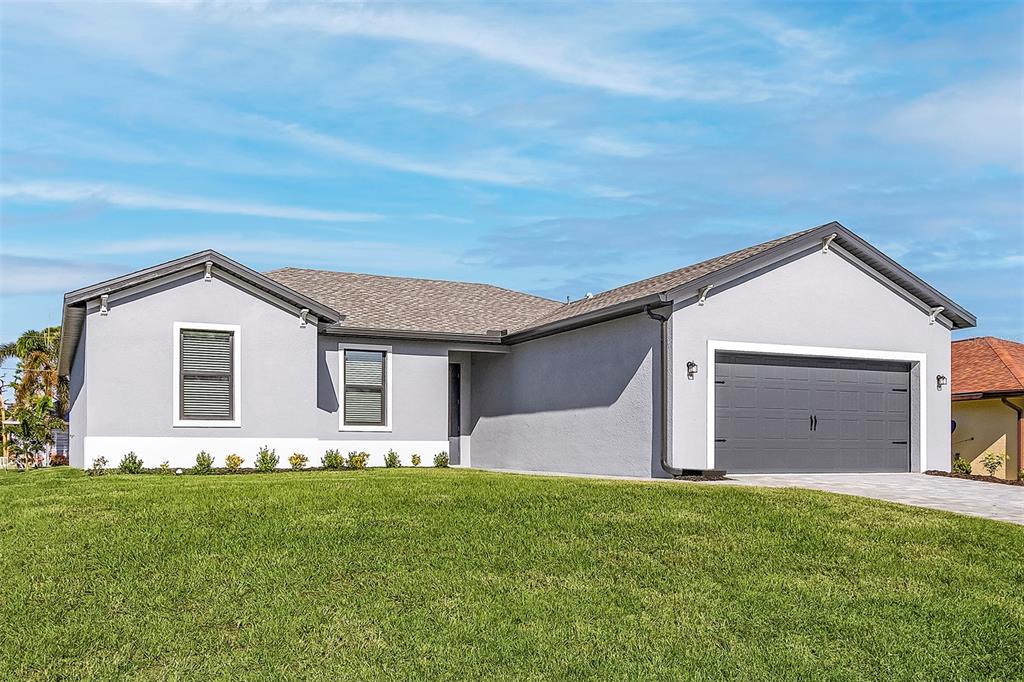 A single-story gray house with a two-car garage and a green lawn under a blue sky — 5321 CRESTLINE TERRACE, PORT CHARLOTTE, FL