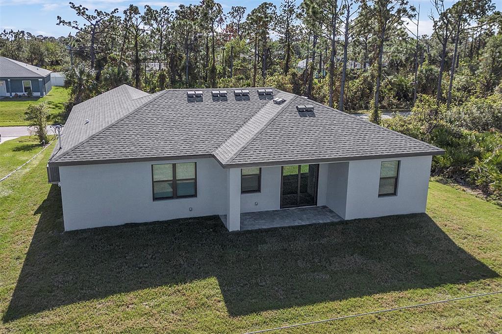 An aerial view of the rear exterior of a single-story house with a shingled roof — 5321 CRESTLINE TERRACE, PORT CHARLOTTE, FL