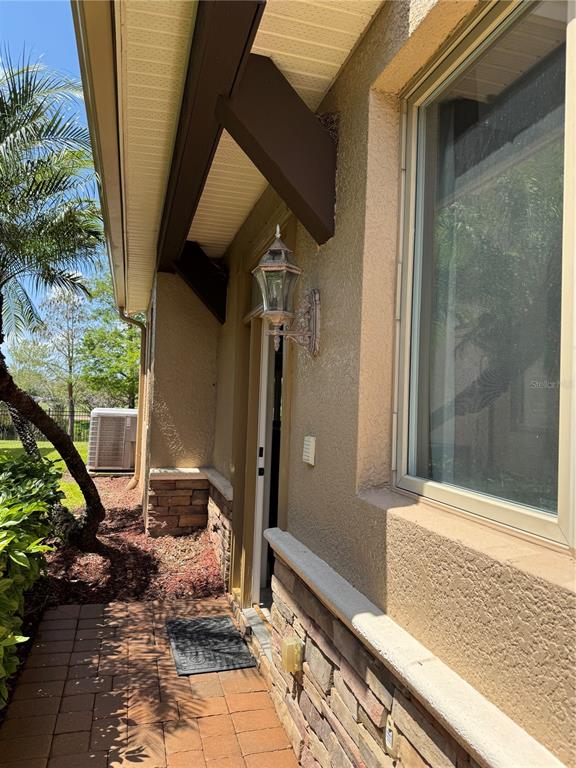 A paved walkway leads to a side entrance with a wall-mounted lantern and stone accents — 644 SAXONY BOULEVARD, ST PETERSBURG, FL
