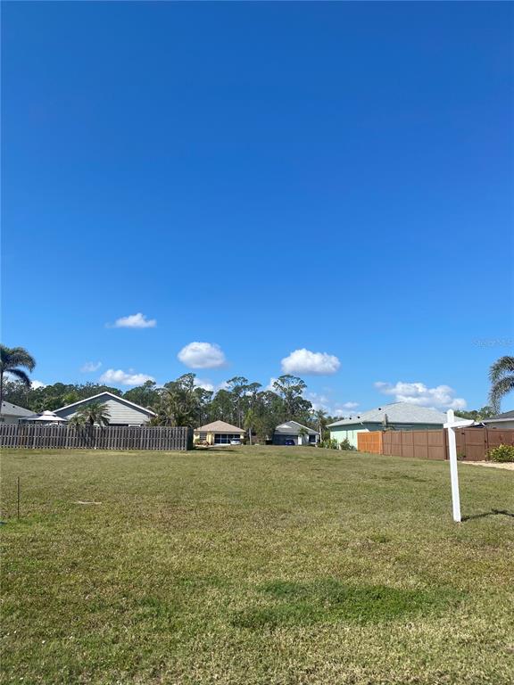 A vacant, grassy residential lot with a real estate sign and surrounding houses — 4280 OAK TERRACE CIRCLE, PORT CHARLOTTE, FL