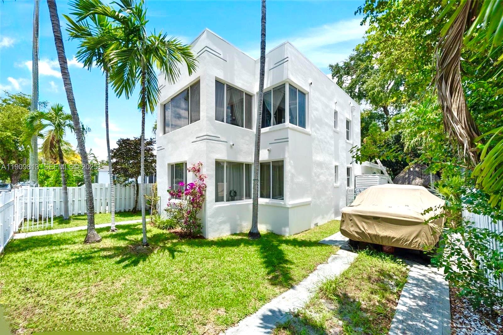 A two-story white stucco building stands in a grassy yard with palm trees — 555 NE 70th St, Miami FL 33138, MIAMI, FL