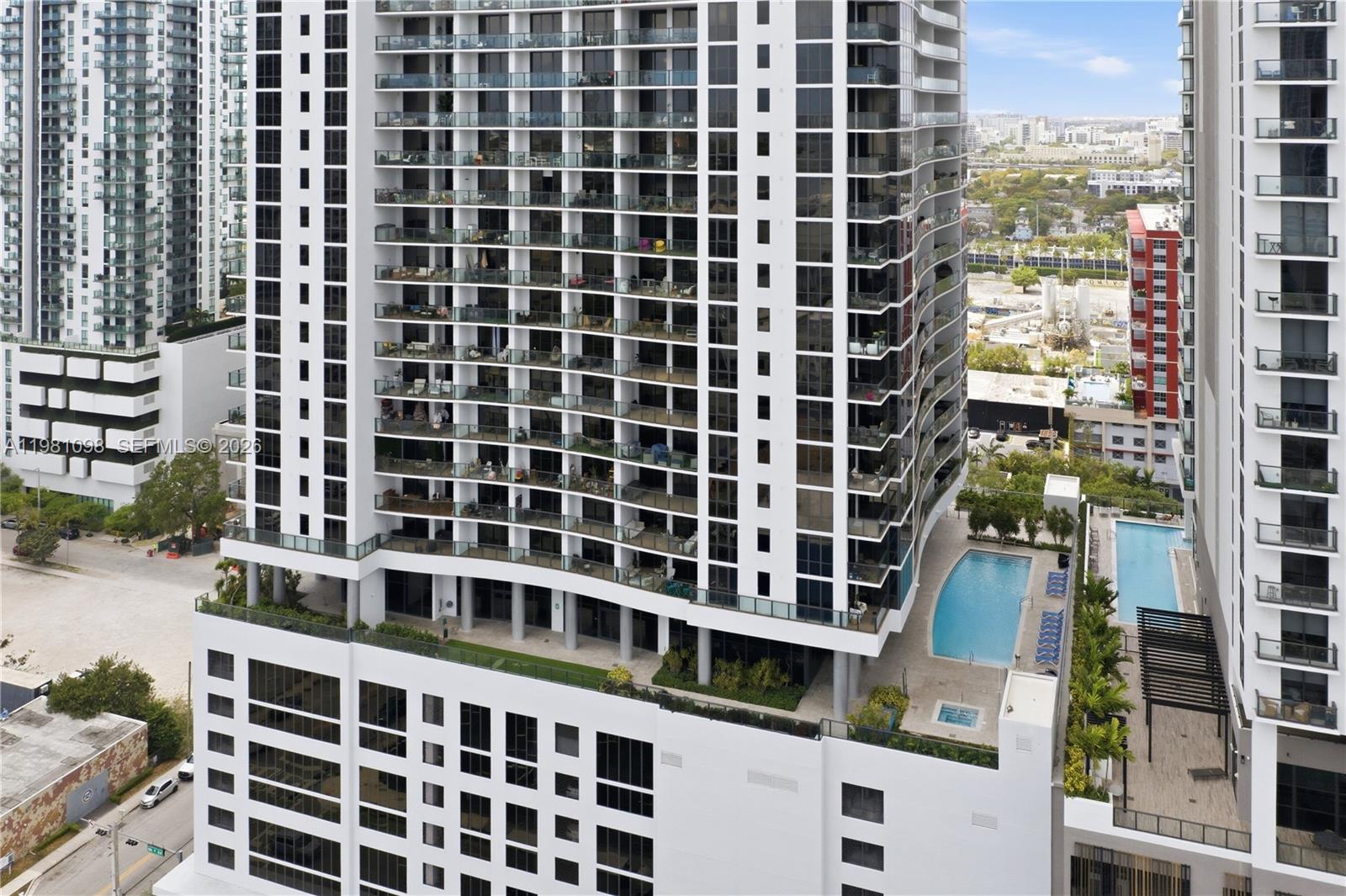An aerial view of a modern high-rise apartment building with balconies and a swimming pool — 1600 NE 1st Ave # 1610, Miami FL 33132, MIAMI, FL