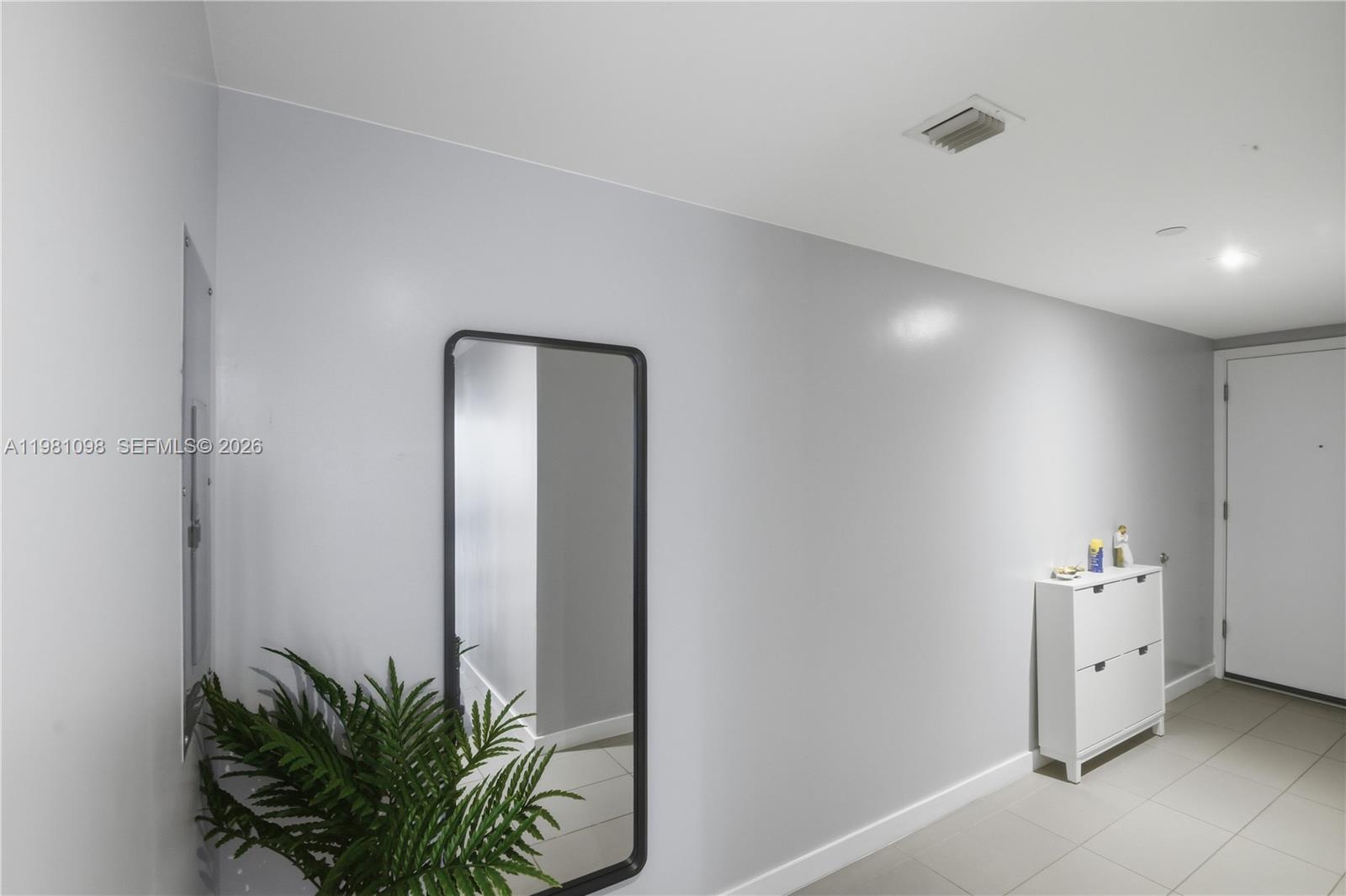A hallway features light gray walls, tile flooring, a tall mirror, and a white cabinet — 1600 NE 1st Ave # 1610, Miami FL 33132, MIAMI, FL