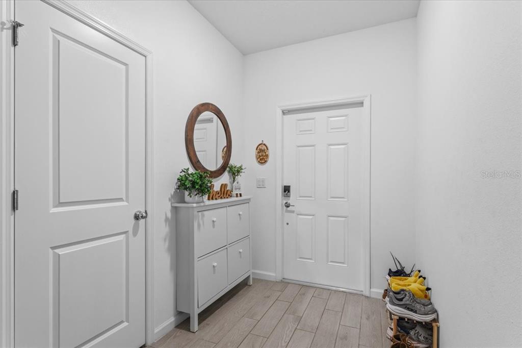An entryway features a white shoe cabinet, a round mirror, and a shoe rack — 12657 NW 7TH PLACE, NEWBERRY, FL
