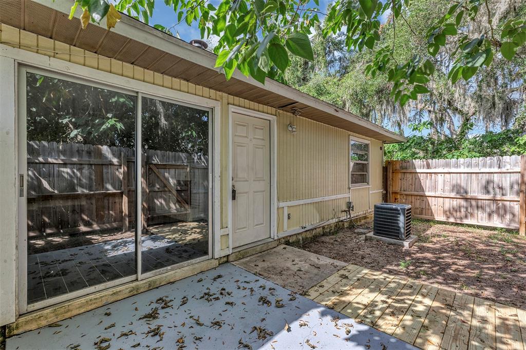 The exterior of a house features a sliding glass door, a white door, and a patio — 3990 SE 17TH COURT, OCALA, FL