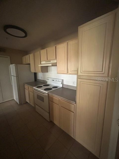 A kitchen features light wood cabinets, a white stove, and a white refrigerator — 425 SUMMIT RIDGE PLACE UNIT 105, LONGWOOD, FL