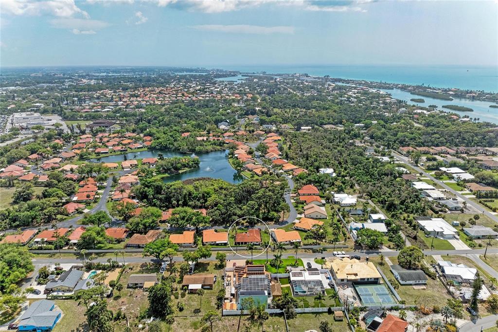 An aerial view shows a residential neighborhood with a circled house near a lake — 246 LAUREL HOLLOW DRIVE UNIT 23, NOKOMIS, FL