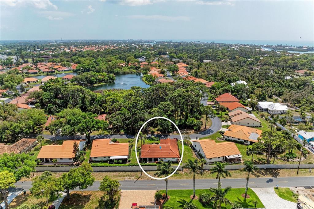 An aerial view shows a residential neighborhood with a circled house featuring a red roof — 246 LAUREL HOLLOW DRIVE UNIT 23, NOKOMIS, FL