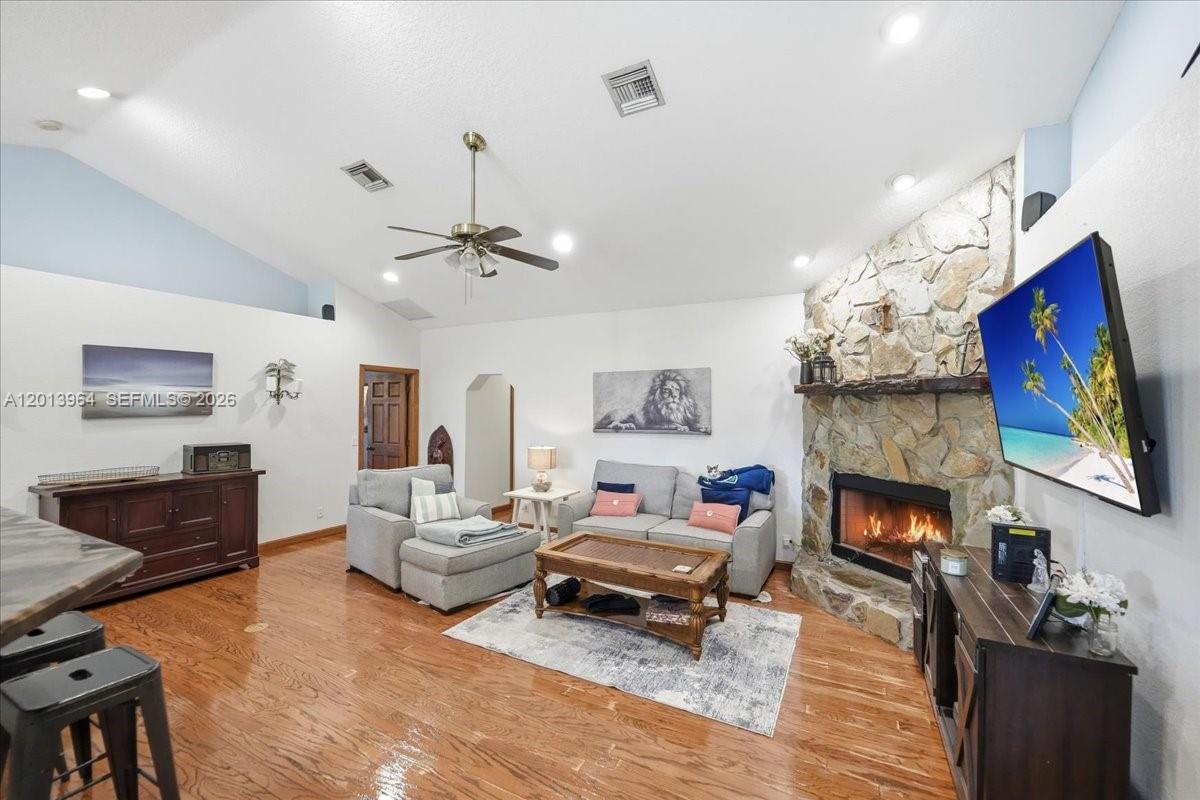 A living room features hardwood floors, a stone fireplace, and a vaulted ceiling with fan — 17857 82nd Rd N, Loxahatchee FL 33470, LOXAHATCHEE, FL