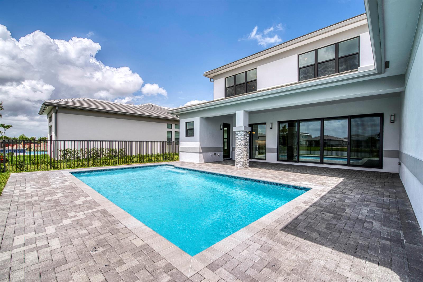 A two-story house with a rectangular swimming pool and a paved patio in the backyard — 13559 Nesting Pines Way, Palm Beach Gardens FL 33412, PALM BEACH GARDENS, FL
