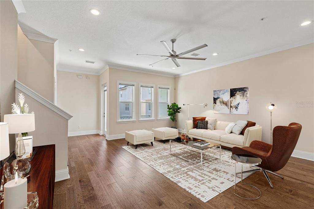 A living room features hardwood floors, a ceiling fan, and a neutral-toned sofa set — 2442 W MISSISSIPPI AVENUE UNIT 14, TAMPA, FL