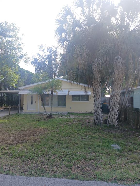 A yellow single-story house with a white door and palm trees in the front yard — 5410 70TH WAY N, ST PETERSBURG, FL