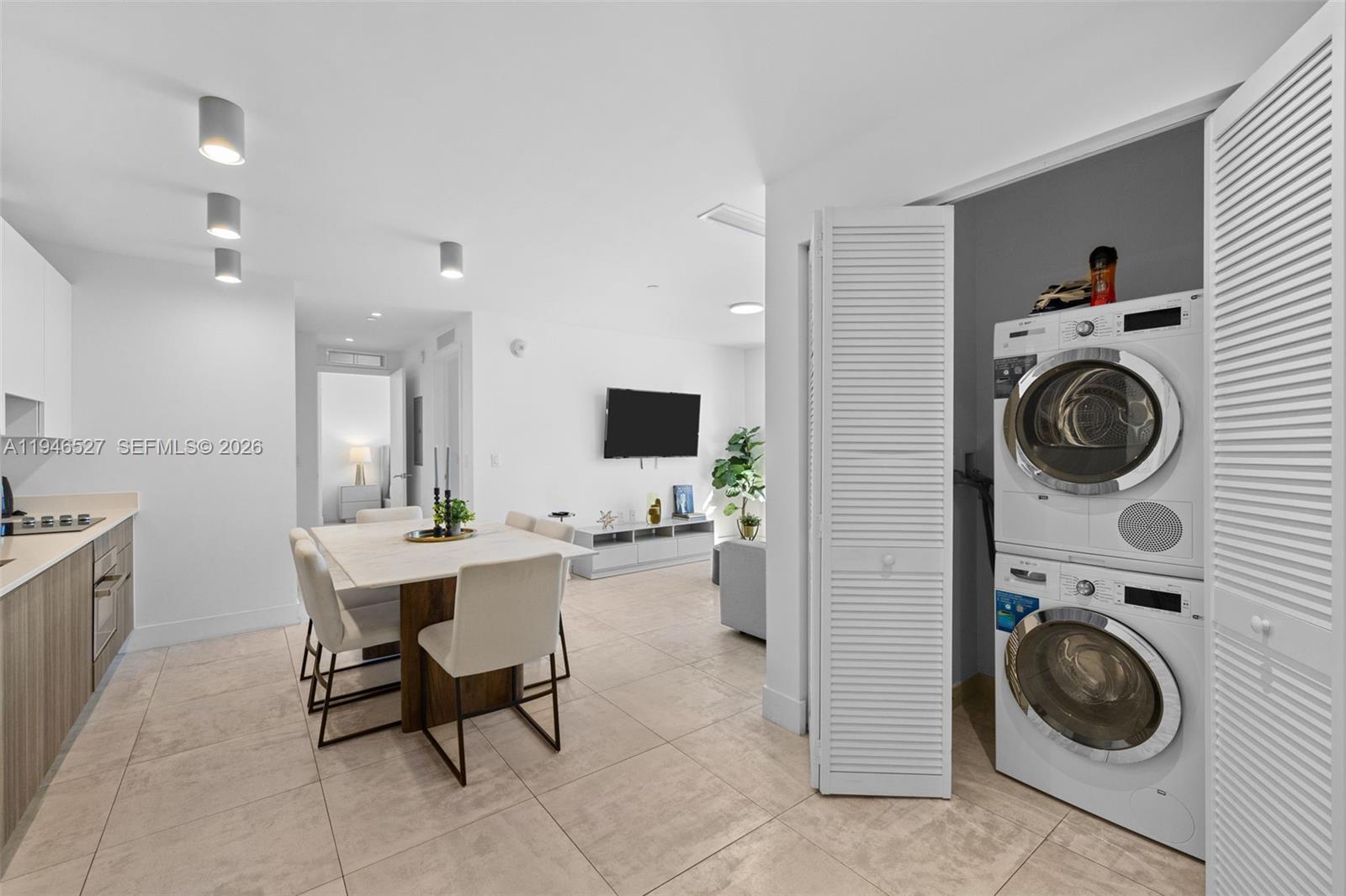 A dining area and kitchen are adjacent to a laundry closet with a stacked washer-dryer — 239 SW 9th St # 2304, Miami FL 33130, MIAMI, FL