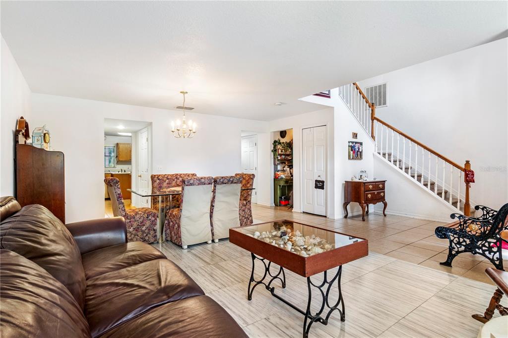 A living and dining area with tile floors, a staircase, and a glass-topped coffee table — 2927 SE 46TH AVENUE, OCALA, FL