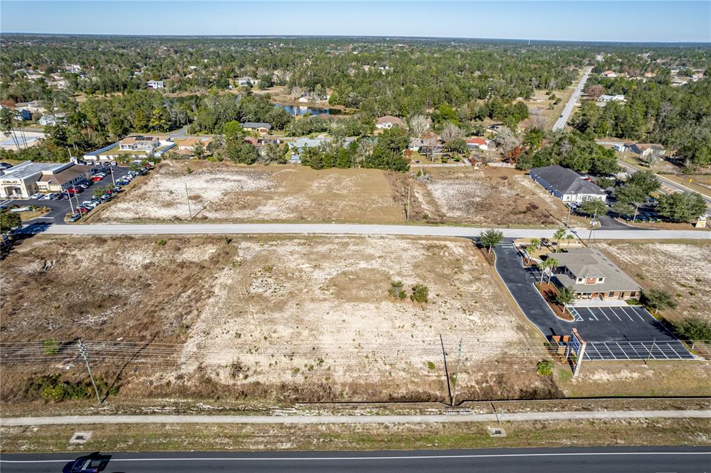 An aerial view shows two large, cleared, undeveloped commercial lots separated by a paved road — 10260 YALE AVENUE, WEEKI WACHEE, FL