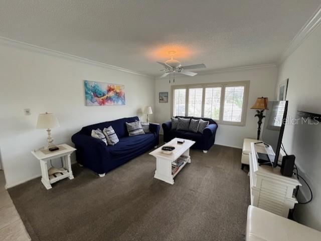A living room features two dark blue sofas, a white coffee table, and a ceiling fan — 6703 MIDNIGHT PASS ROAD UNIT 217, SARASOTA, FL