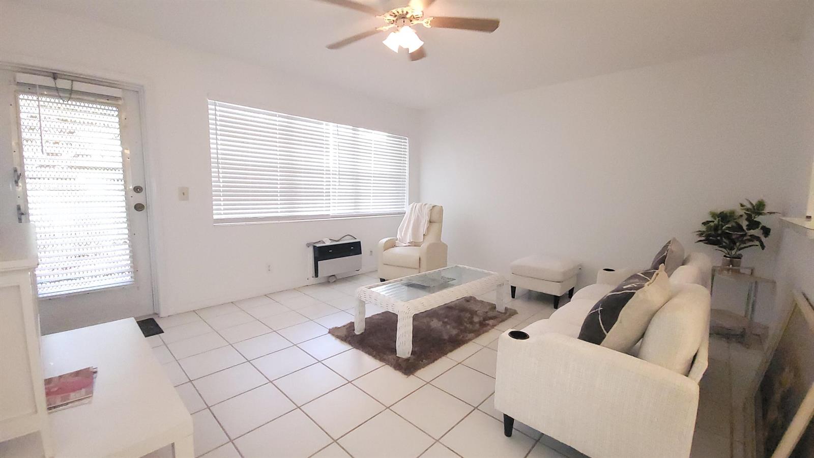 A bright living room features white tile floors, a ceiling fan, and white furniture — 319 Chatham P, West Palm Beach FL 33417, WEST PALM BEACH, FL