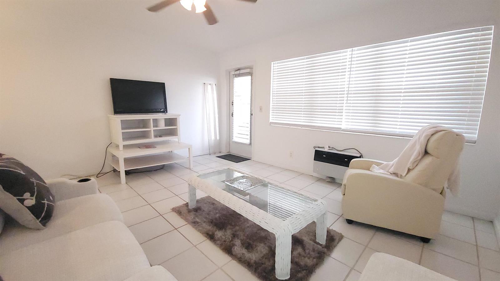 A living room features white tile floors, a glass coffee table, and a white recliner — 319 Chatham P, West Palm Beach FL 33417, WEST PALM BEACH, FL
