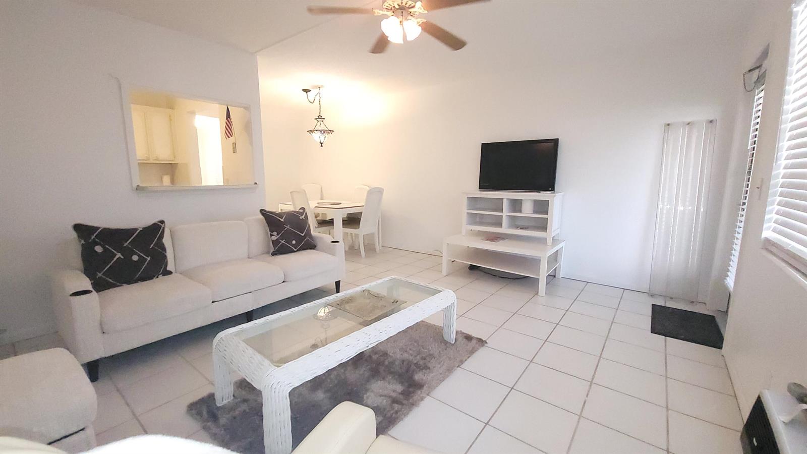 A living room features white tile floors, a white sofa, and a glass coffee table — 319 Chatham P, West Palm Beach FL 33417, WEST PALM BEACH, FL