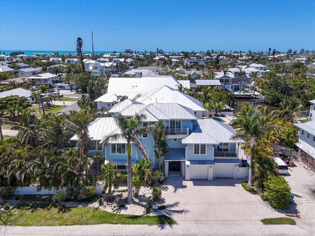 An aerial view of a light blue multi-story coastal home with a white metal roof — 222 WILLOW AVENUE, ANNA MARIA, FL