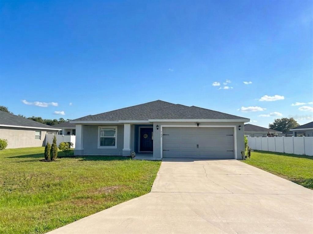 A single-story house with a gray exterior, a two-car garage, and a concrete driveway — 9134 SE 43RD TERR, OCALA, FL