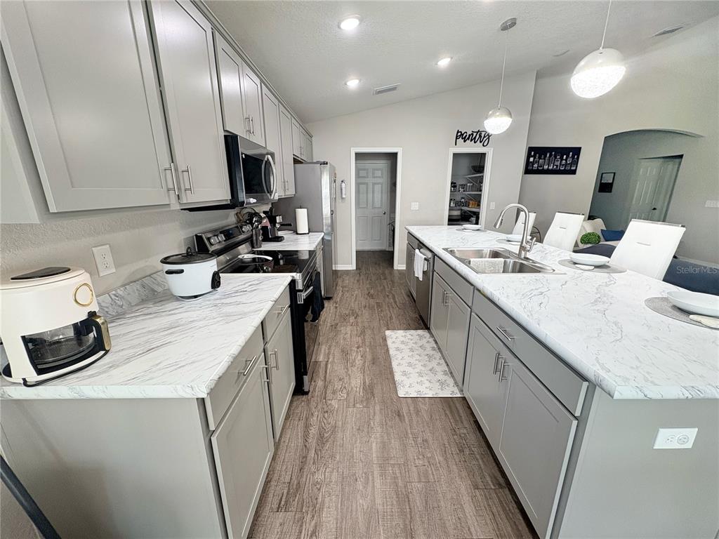 A covered front entryway features a dark gray door with a decorative hello sign — 9134 SE 43RD TERR, OCALA, FL