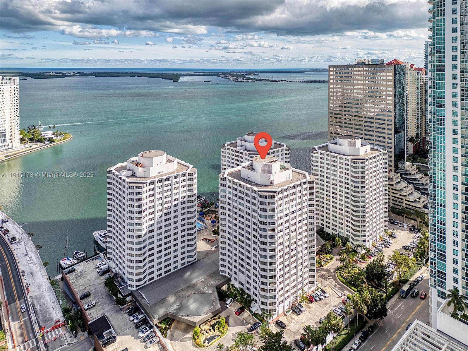 An aerial view shows three white residential towers situated along a waterfront with parking lots — 825 Brickell Bay Dr # 1942, Miami FL 33131, MIAMI, FL
