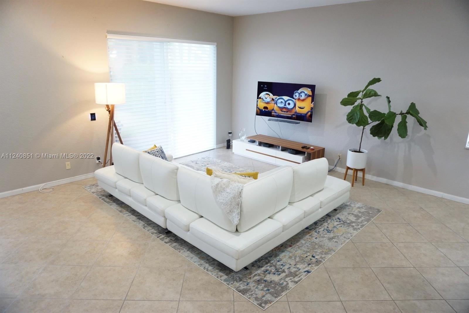 A living room features a white sectional sofa, a television, and a potted plant — 878 Lavender Circle # 878, Weston FL 33327, WESTON, FL