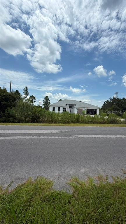 A single-story white house with a gray roof sits behind a road and vegetation — 0 NETTLETON STREET, ORLANDO, FL