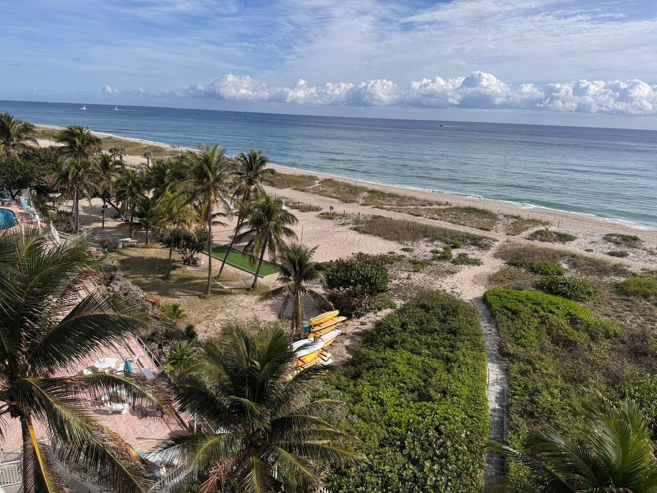 An elevated view of a sandy beach with palm trees, vegetation, and the ocean — 704 N Ocean Boulevard # 504, Pompano Beach FL 33062, POMPANO BEACH, FL