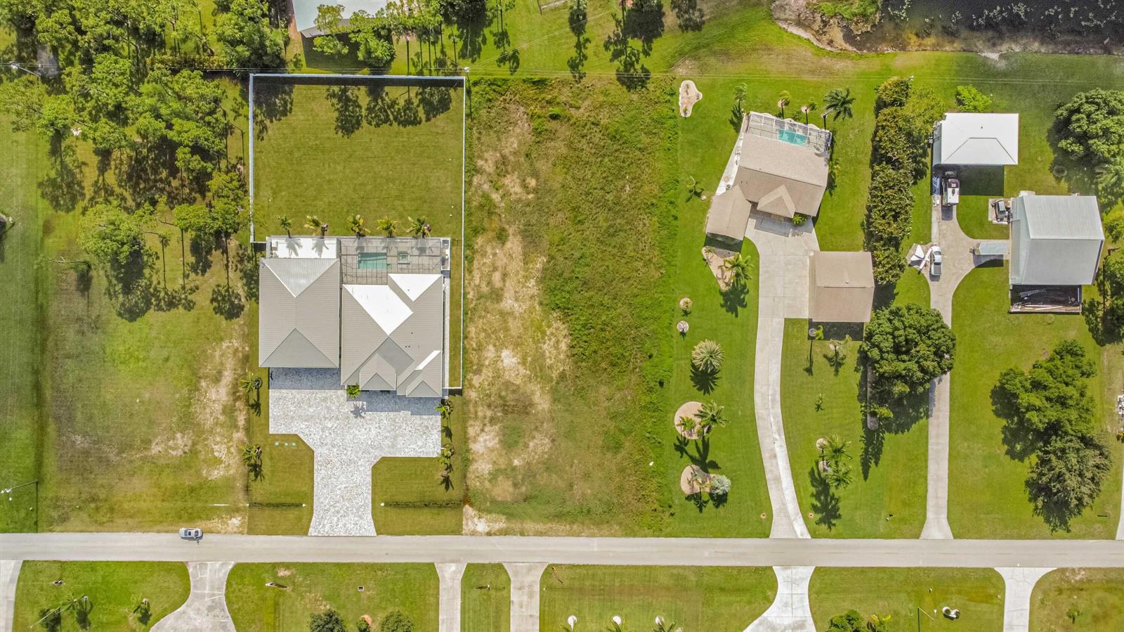 An aerial view shows a house with a pool and a large adjacent vacant lot — 18742 Crosswind Avenue, FL 33917, FL