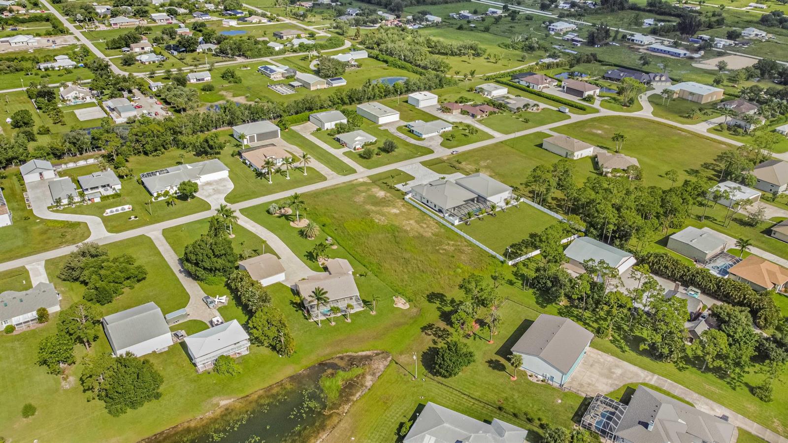 An aerial view shows a residential neighborhood with single-family homes, large lots, and green lawns — 18742 Crosswind Avenue, FL 33917, FL
