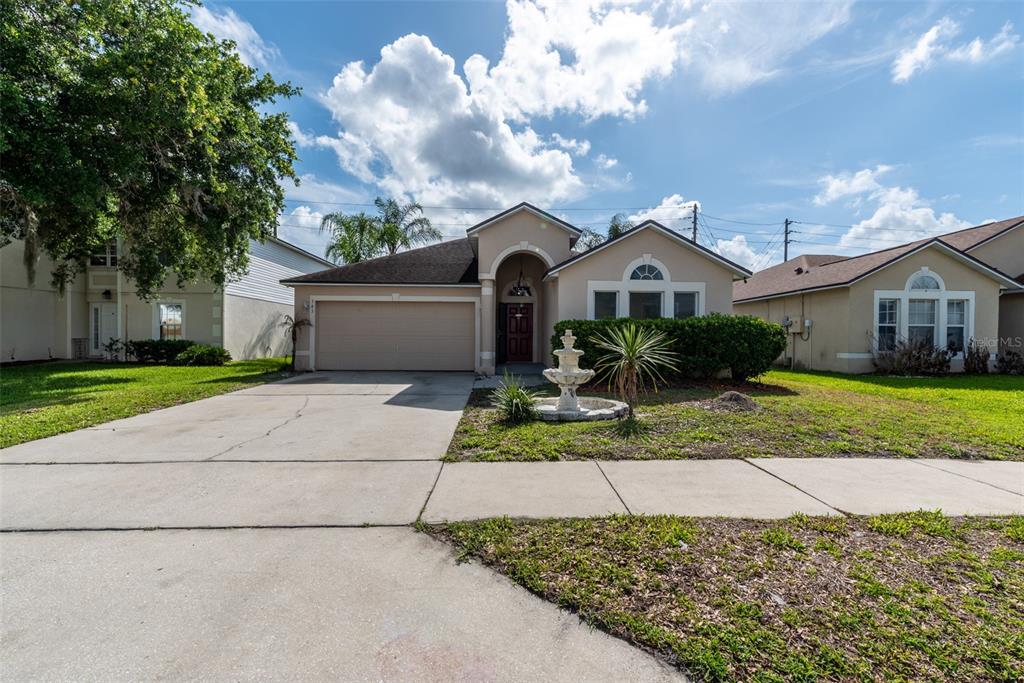 A single-story suburban house features a two-car garage, a front fountain, and a concrete driveway — 383 FAIRFIELD DRIVE, SANFORD, FL